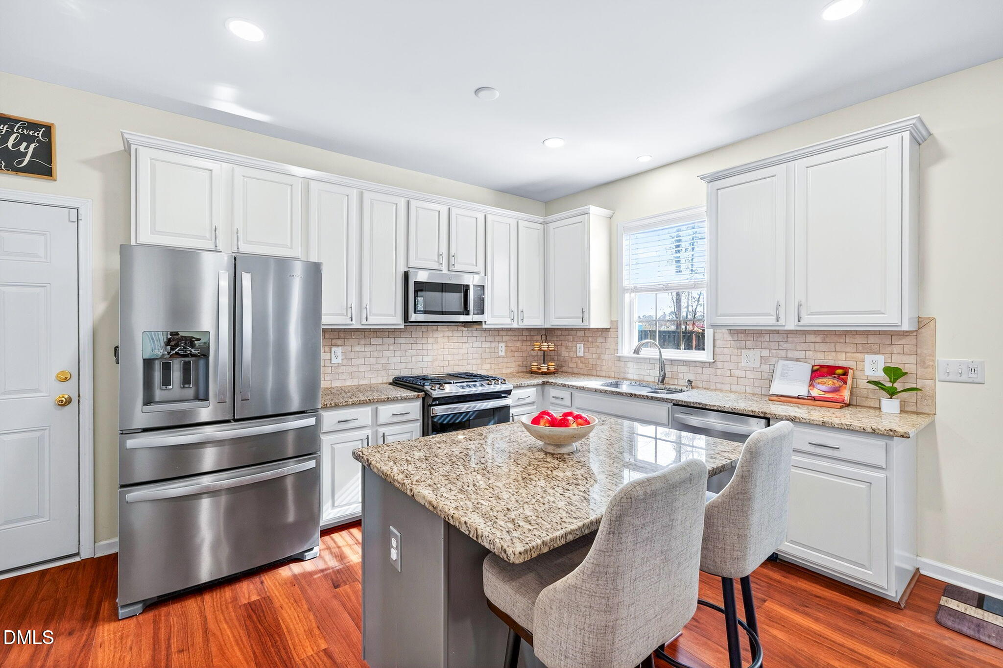 708 Quiet Walk Circle Rolesville, NC 27571 - Photo 6 of 56 a kitchen with stainless steel appliances granite countertop a refrigerator a sink dishwasher a stove and white countertops with wooden floor