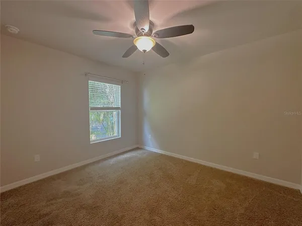 an empty room with closet and fan