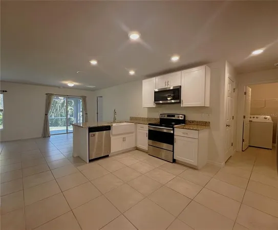 a kitchen with stainless steel appliances a refrigerator sink and microwave