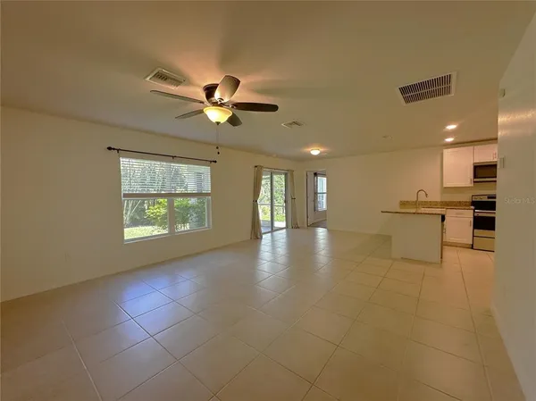 a view of an empty room with a kitchen stove and a window