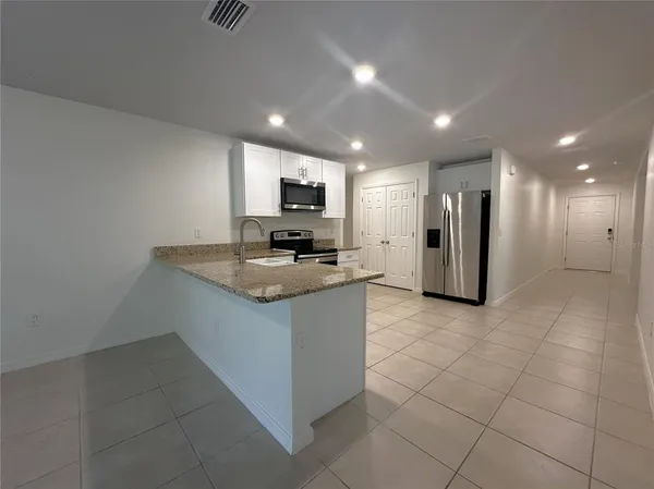 a kitchen with stainless steel appliances a refrigerator sink and microwave