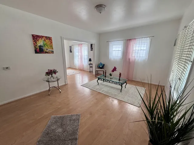 a living room with furniture and wooden floor