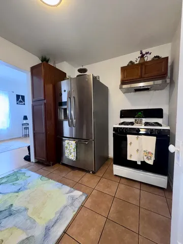 a kitchen with stainless steel appliances granite countertop a refrigerator and a stove