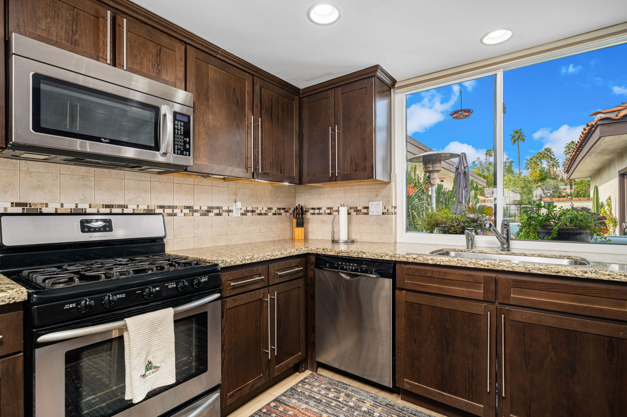 21 Toledo Drive Rancho Mirage, CA 92270 - Photo 14 of 35 a kitchen with stainless steel appliances a stove a sink and a microwave