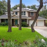 a front view of a house with a yard and potted plants