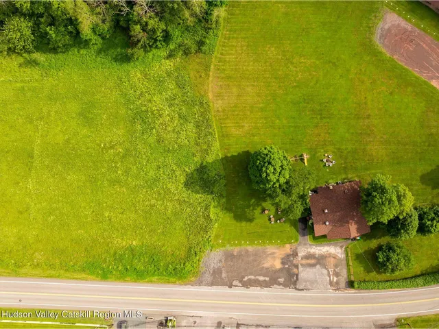 an aerial view of residential houses with outdoor space and trees