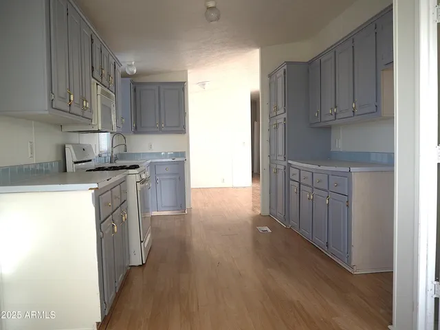 a kitchen with granite countertop wooden cabinets and white appliances