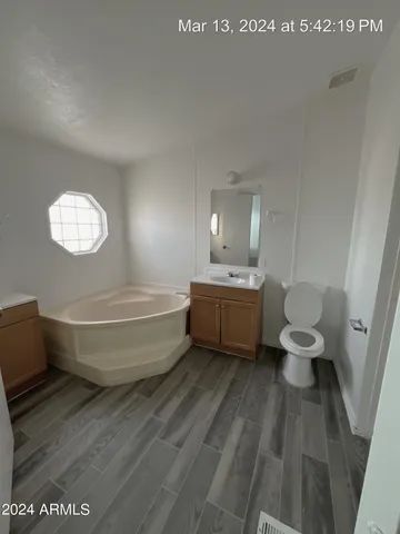 a bathroom with a sink a toilet a mirror and bathtub