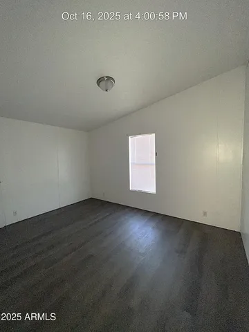 an empty room with wooden floor and windows in it