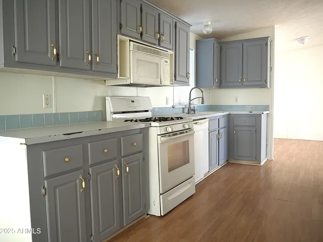 a kitchen with cabinets appliances a sink and a counter top space