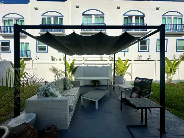 a view of houses with a table and chairs under an umbrella