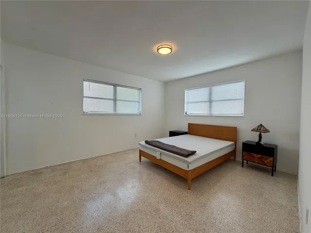 a bedroom with bed and a window