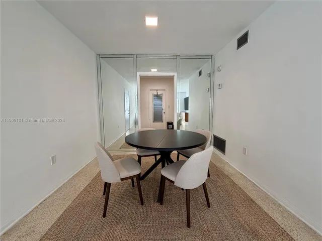 a view of a dining room with a table and chairs