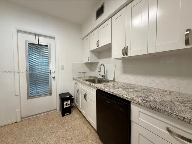 a kitchen with granite countertop stainless steel appliances a sink stove and refrigerator