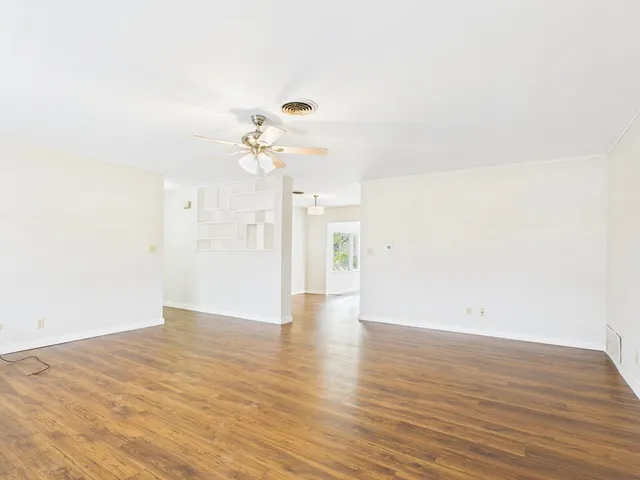 a view of an empty room with wooden floor