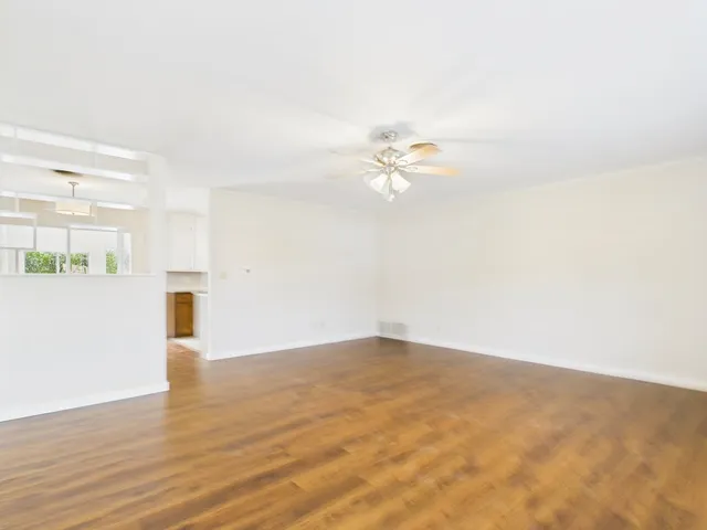 a view of an empty room with wooden floor