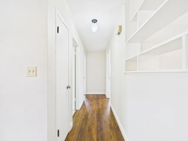 a view of a hallway with wooden floor
