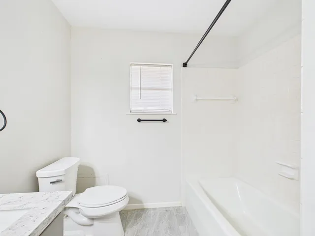 a white toilet sitting next to a bath tub