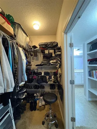 a view of walk in closet with clothes and shoes