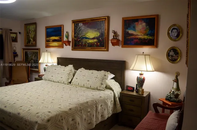 a bedroom with a bed and a lamp on dresser