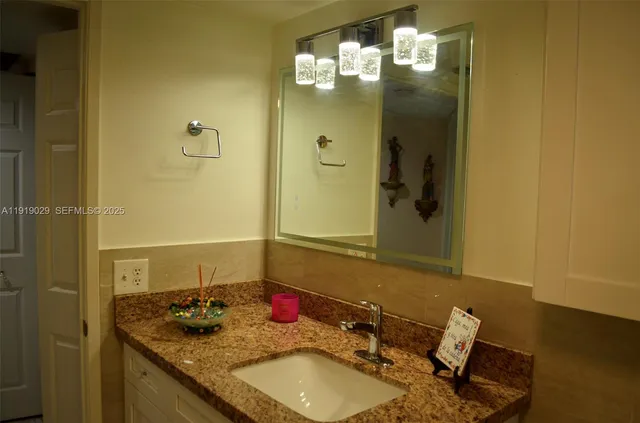 a bathroom with a granite countertop sink and a mirror