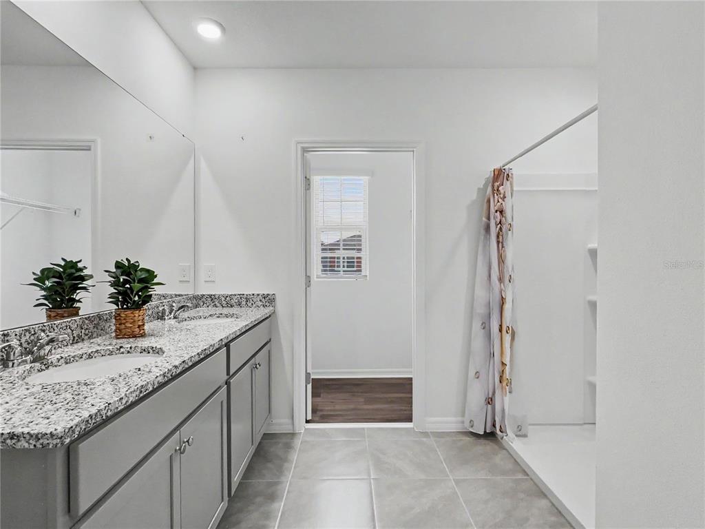 2085 Doe Run Drive Davenport, FL 33837 - Photo 29 of 44 a bathroom with a granite countertop sink and a mirror