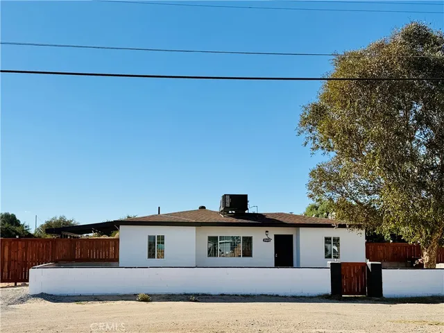 a front view of a house with a large tree and a outdoor space
