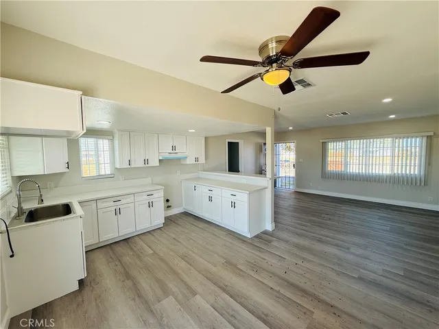 a kitchen with a white cabinets and wooden floor