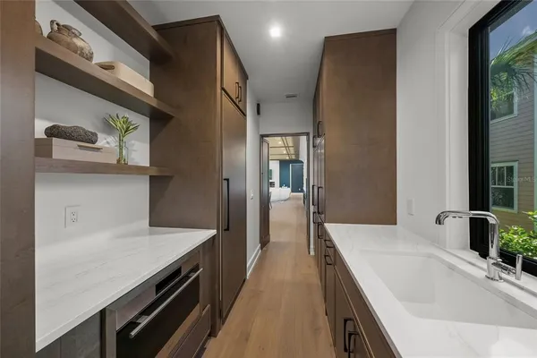 a hallway with a sink and wooden floor