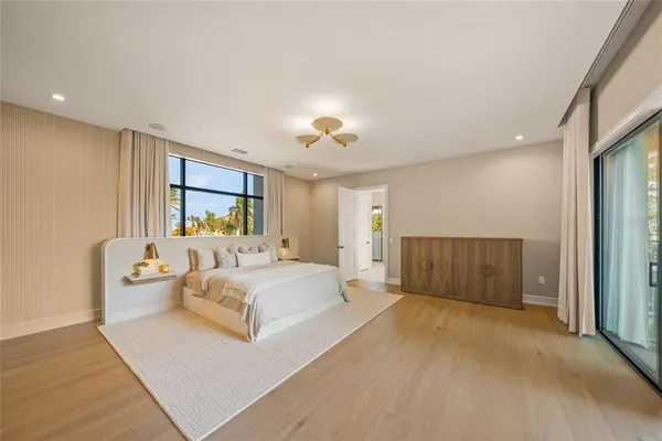 a spacious bedroom with a large bed and a chandelier