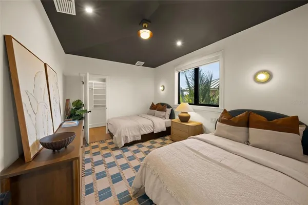 a spacious bedroom with a bed and a potted plant