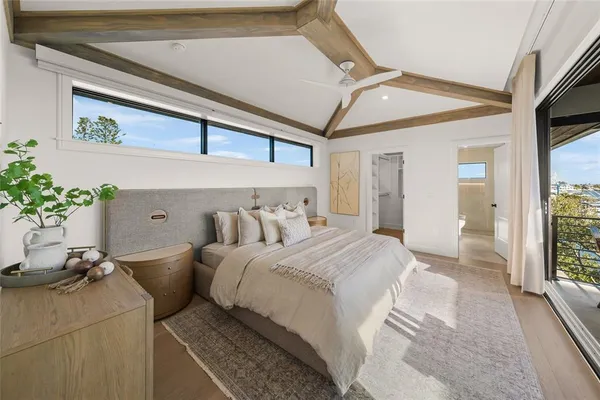 a bedroom with a bed and large windows