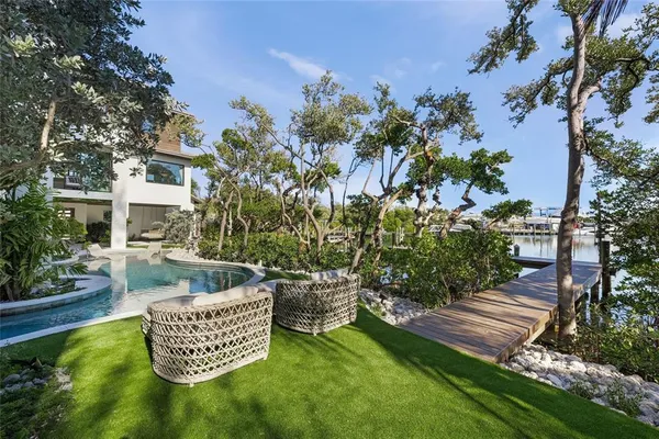 a front view of a house with garden and sitting area
