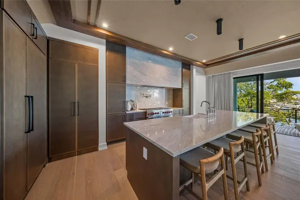 a view of kitchen island a sink a refrigerator and a table