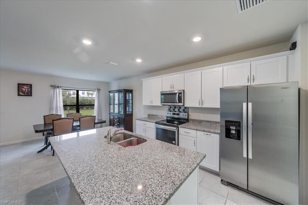 4596 Lamaida Lane Immokalee, FL 34142 - Photo 9 of 22 a kitchen with stainless steel appliances granite countertop a refrigerator stove microwave and sink