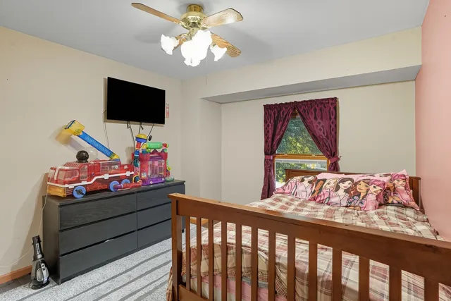 a bedroom with furniture and a flat screen tv