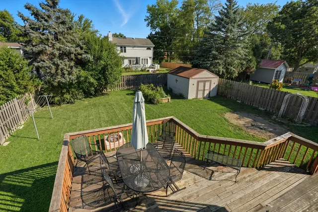 a view of a chair and table on the wooden deck