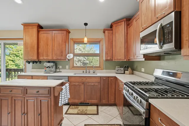 a kitchen with stainless steel appliances a sink dishwasher stove and cabinets