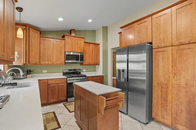 a kitchen with stainless steel appliances granite countertop a refrigerator stove and sink