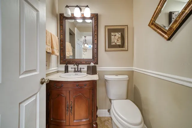 a bathroom with a granite countertop toilet sink and mirror