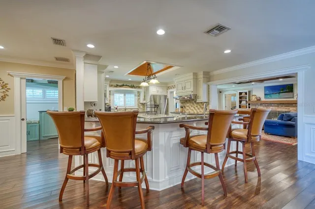 a dining room with wooden floor a glass table and chairs
