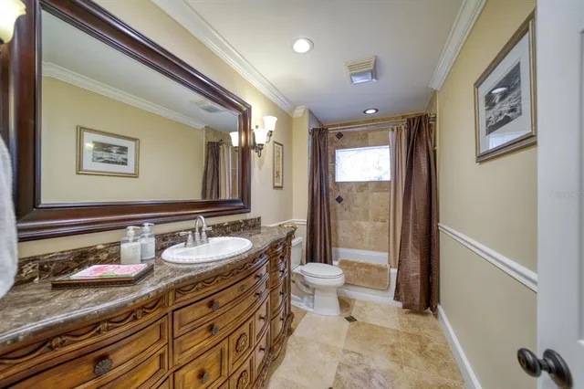 a bathroom with a granite countertop sink a toilet a mirror and shower