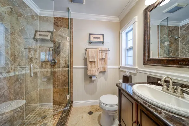 a bathroom with a granite countertop sink toilet and shower