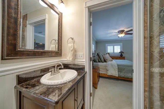 a en suite bathroom with a granite countertop sink and a mirror