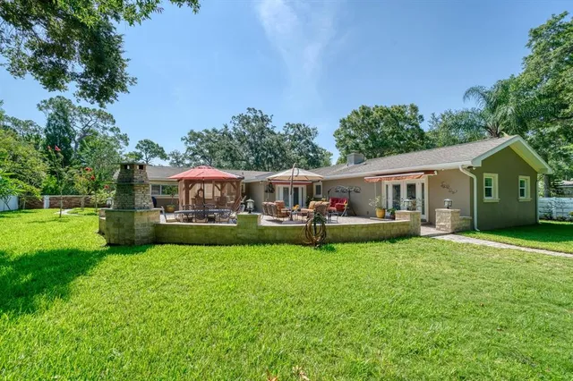 a view of a house with a yard and sitting area