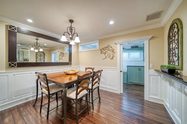 a dining room filled chandelier and wooden floor