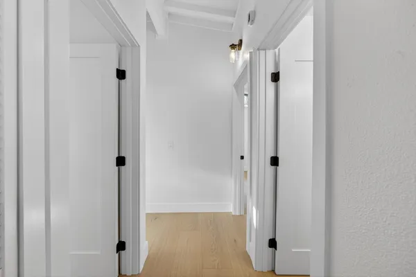 a view of empty room with wooden floor