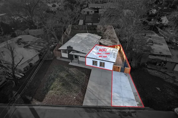 a view of a house with a yard and large tree