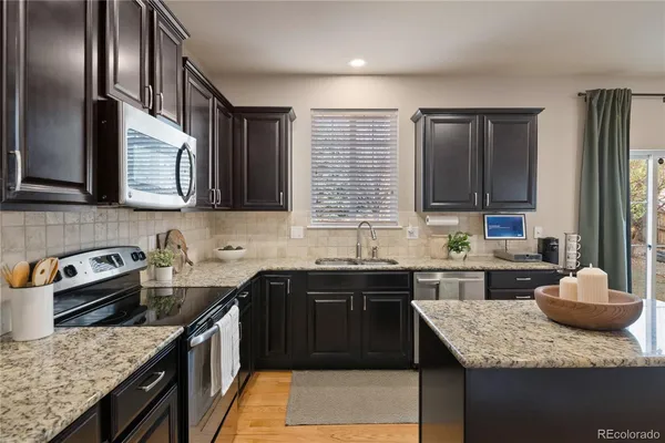 a kitchen with stainless steel appliances granite countertop a sink stove and cabinets