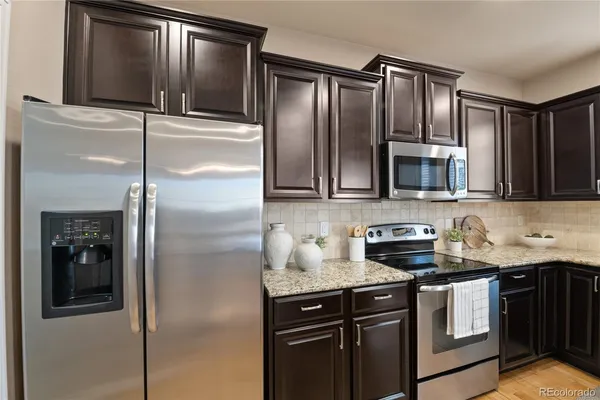 a kitchen with stainless steel appliances granite countertop a refrigerator and a microwave